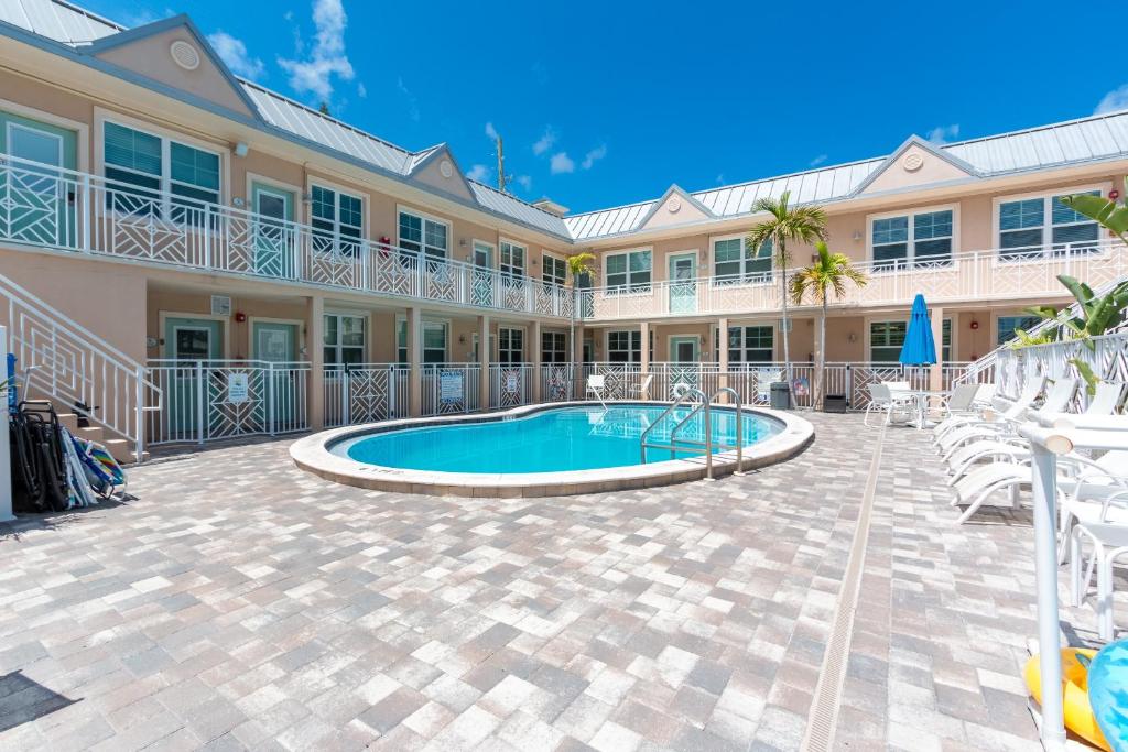 un complejo con piscina, sillas y un edificio en Clearwater Beach Suites 204 condo, en Clearwater Beach
