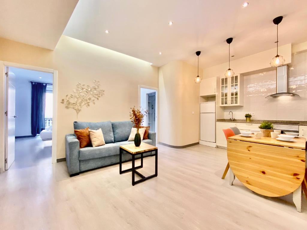 ein Wohnzimmer mit einem Sofa und einem Tisch in der Unterkunft Charming Puerta del Sol Center - 6 Bedrooms in Madrid