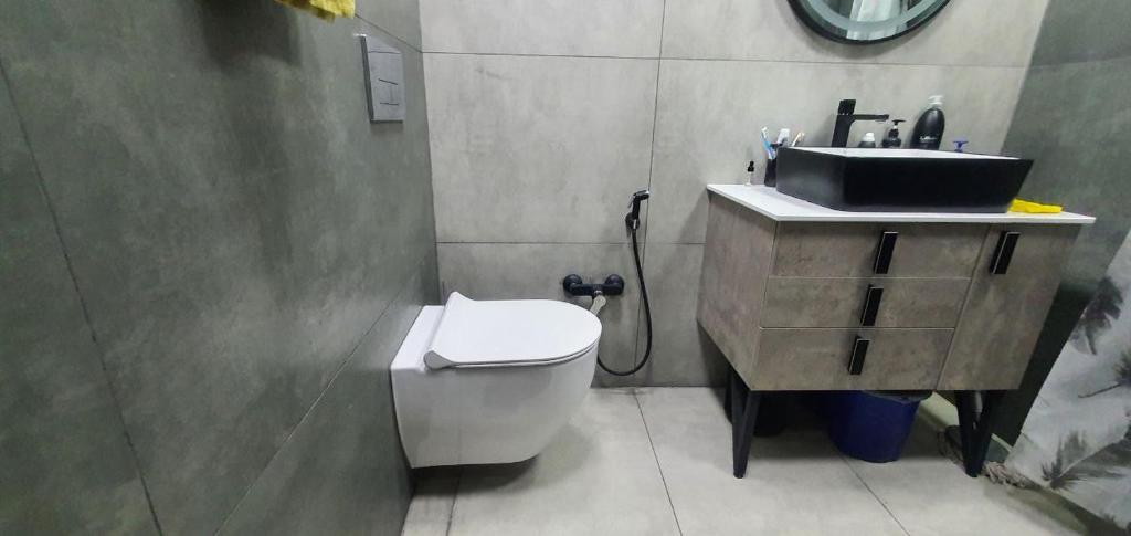 a bathroom with a white toilet and a sink at Уютная трехкомнатная квартира с видом на море в Баку in Baku