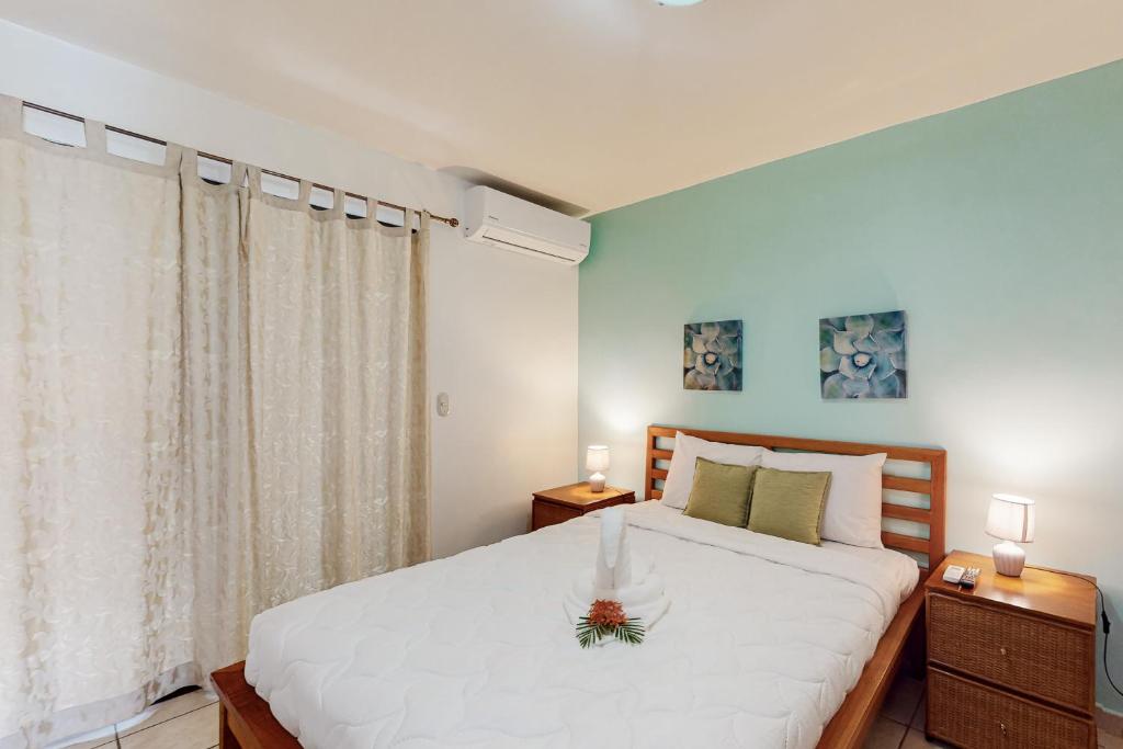 ein Schlafzimmer mit einem großen weißen Bett und zwei Nachttischen in der Unterkunft Flamenco Rosa A13 in Coco