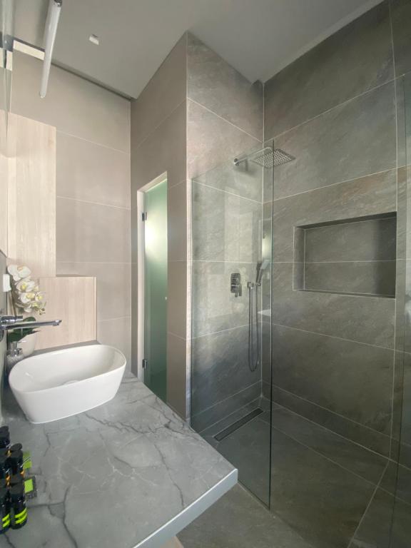 a bathroom with a glass shower and a sink at Serendipity Living in Kythira