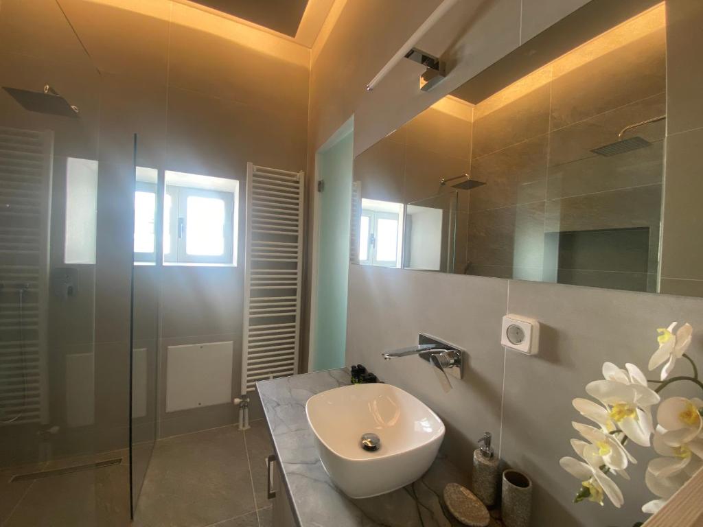 a bathroom with a sink and a glass shower at Serendipity Living in Kythira