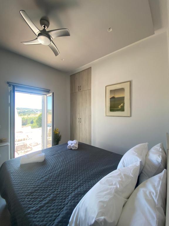 a bedroom with a bed and a ceiling fan at Serendipity Living in Kythira