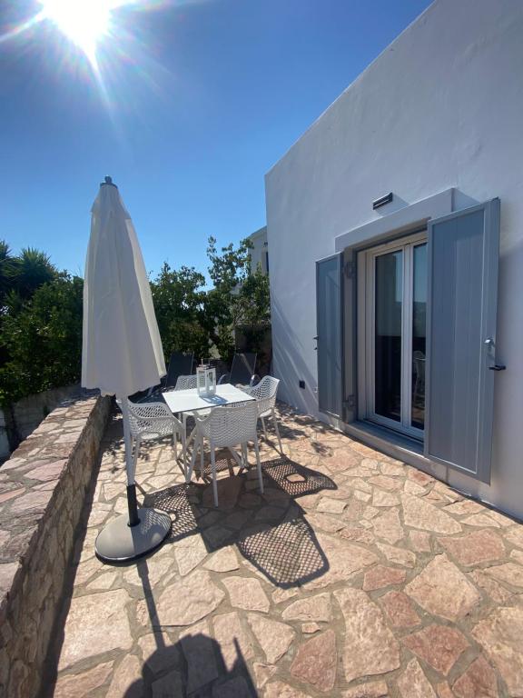 a patio with an umbrella and a table and chairs at Serendipity Living in Kythira