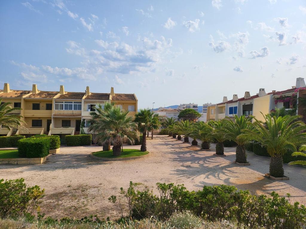 einen Innenhof mit Palmen vor den Gebäuden in der Unterkunft Casa frente al mar con Vistas in Oliva