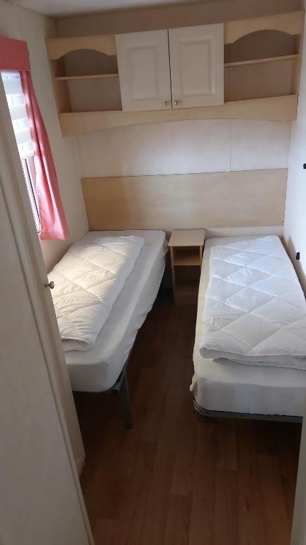 ein kleines Zimmer mit 2 Betten und einem Fenster in der Unterkunft Le petit rio in Noyelles-sur-Mer