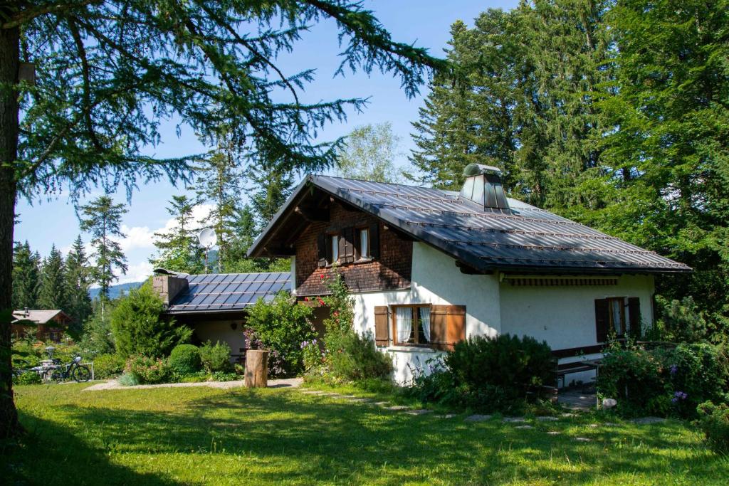 una casa con techo de estaño en un patio verde en Ferienhaus Schetteregg, en Egg