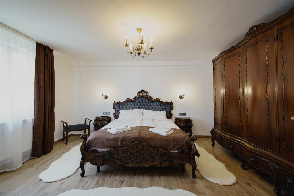 a bedroom with a large bed and a chandelier at CASA BARONULUI in Baia Mare