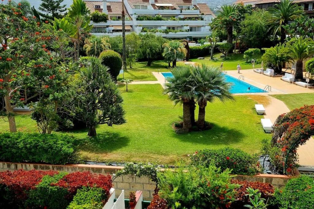 a view of a park with a swimming pool and palm trees at FlordeTajinaste in Puerto de la Cruz