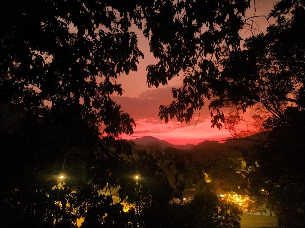a sunset view of a city with lights at Kakuna Lodge in Minca