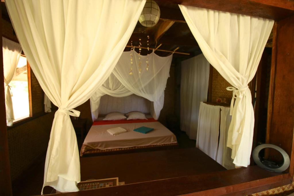 Ένα ή περισσότερα κρεβάτια σε δωμάτιο στο Palawan Ecolodge