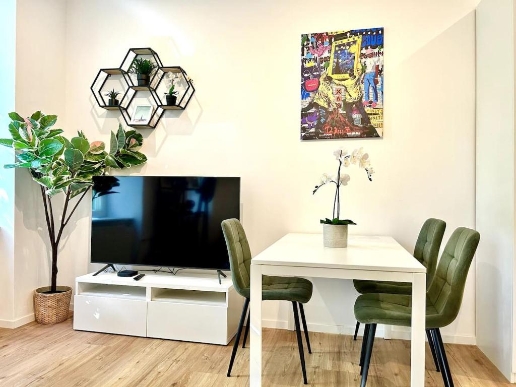 a dining room with a white table and a tv at Modern Stylish Studio near Center in Vienna