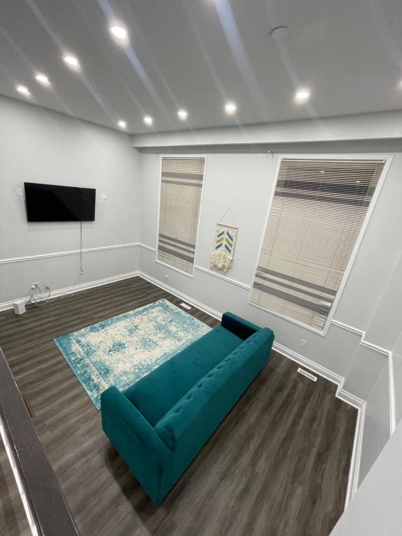 ein Wohnzimmer mit einem blauen Sofa und einem Flachbild-TV in der Unterkunft Mo's Place in Mississauga