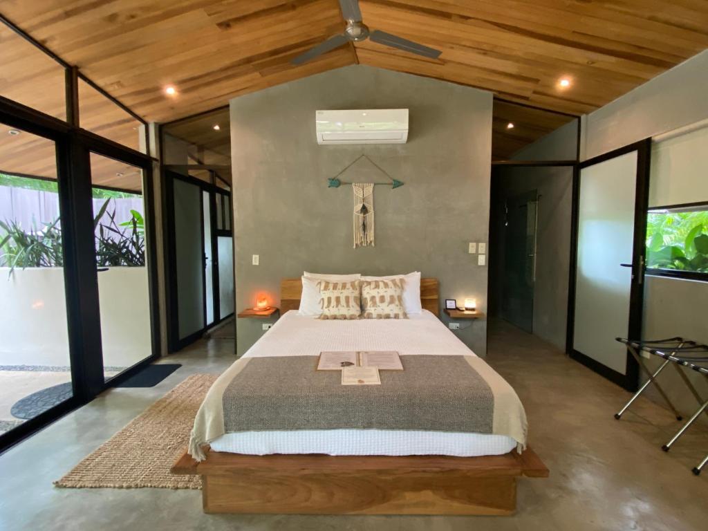 ein Schlafzimmer mit einem großen Bett in einem Zimmer mit Fenstern in der Unterkunft Villas Kalei in Playa Grande