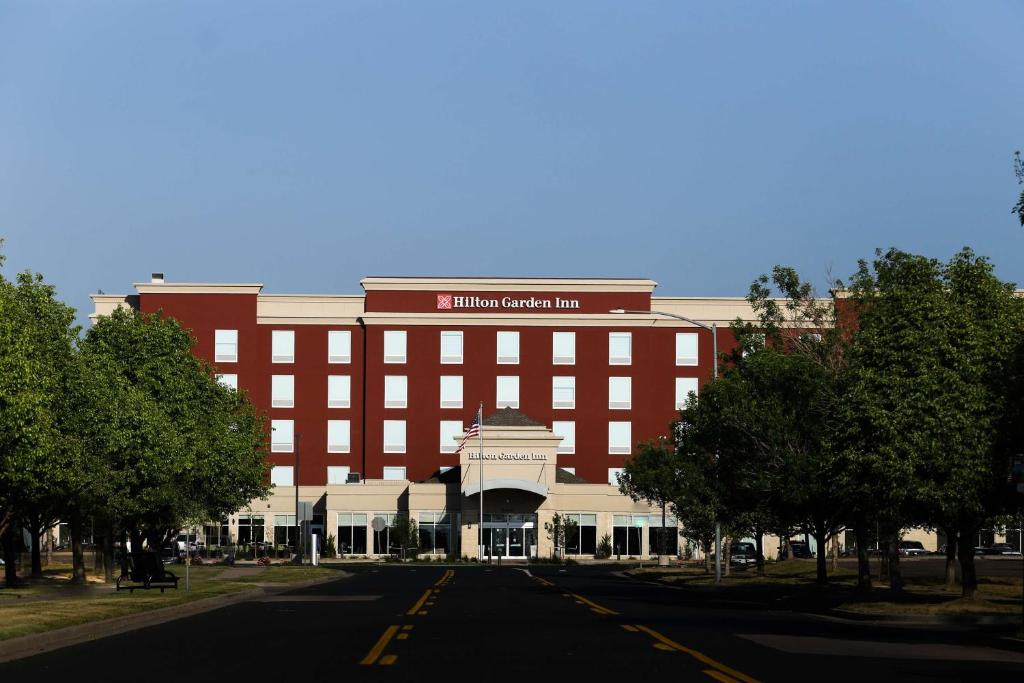 un gran edificio rojo con un cartel en él en Hilton Garden Inn Arvada/Denver, CO en Arvada