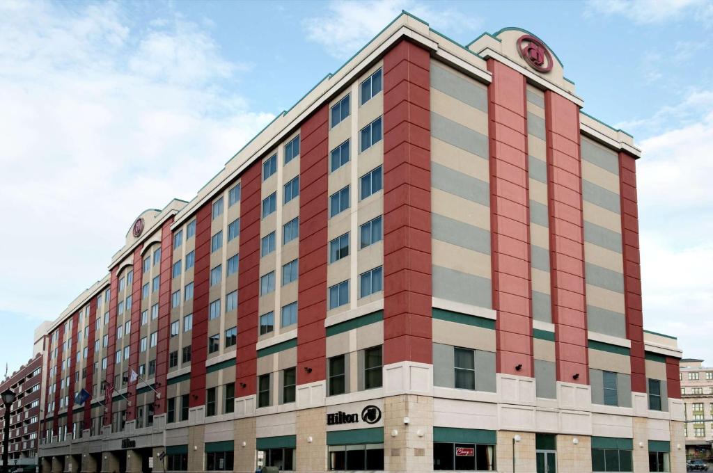 Hilton Scranton & Conference Center في سكرانتون: مبنى احمر وبيض مع وضع ساعة في الاعلى