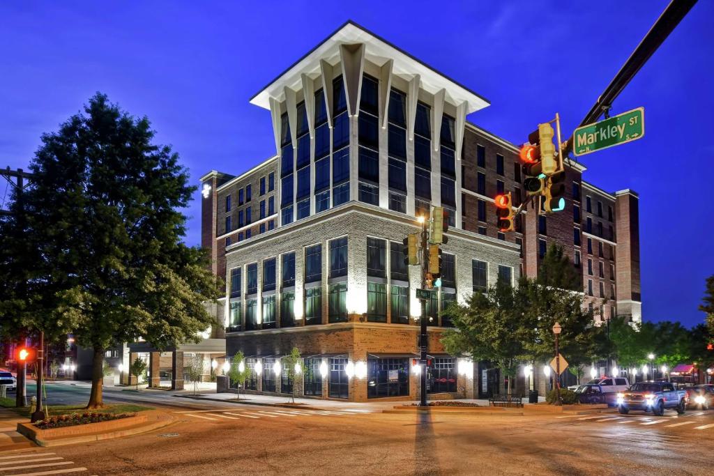 un edificio en la esquina de una calle por la noche en Homewood Suites By Hilton Greenville Downtown, en Greenville