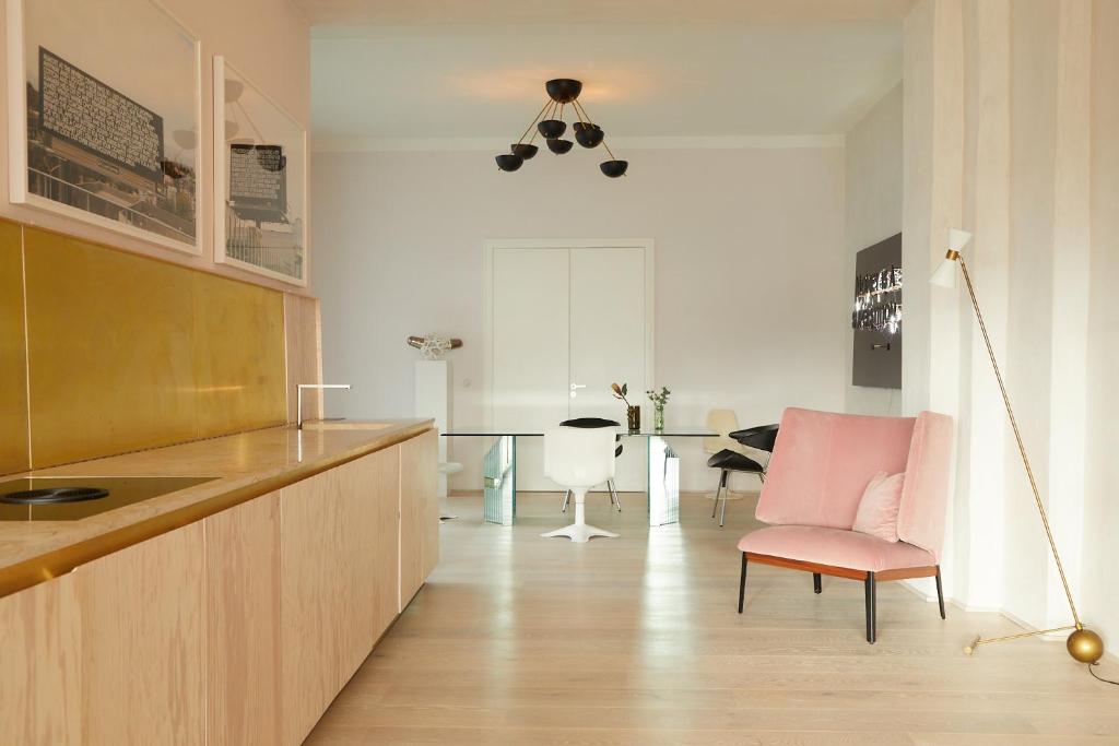 uma cozinha com uma cadeira rosa e uma mesa em Stadtflucht Loft 3.1.1 em Berlim