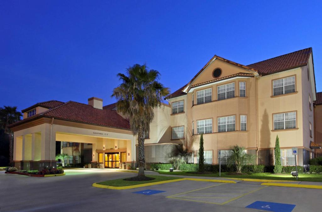 ザ・ウッドランズにあるHomewood Suites by Hilton Houston-Woodlands-Shenandoahのヤシの木が目の前に広い建物