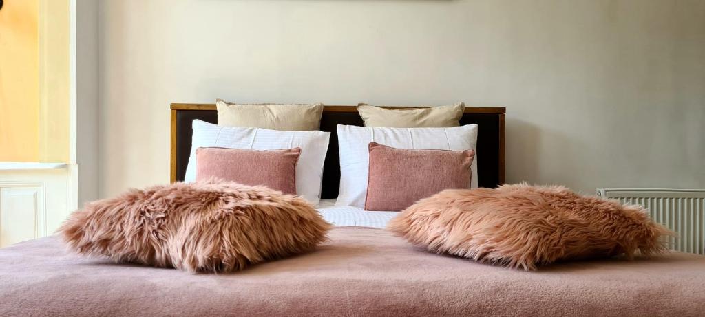 two furry pillows sitting on top of a bed at Livada Studio Apartments in Braşov
