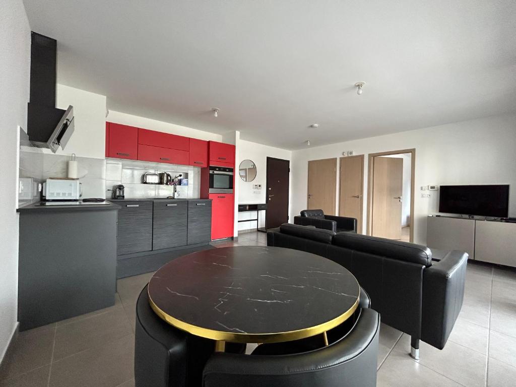 a kitchen and living room with a table and chairs at Résidence les Iris - T2 au pied du tram in Annemasse