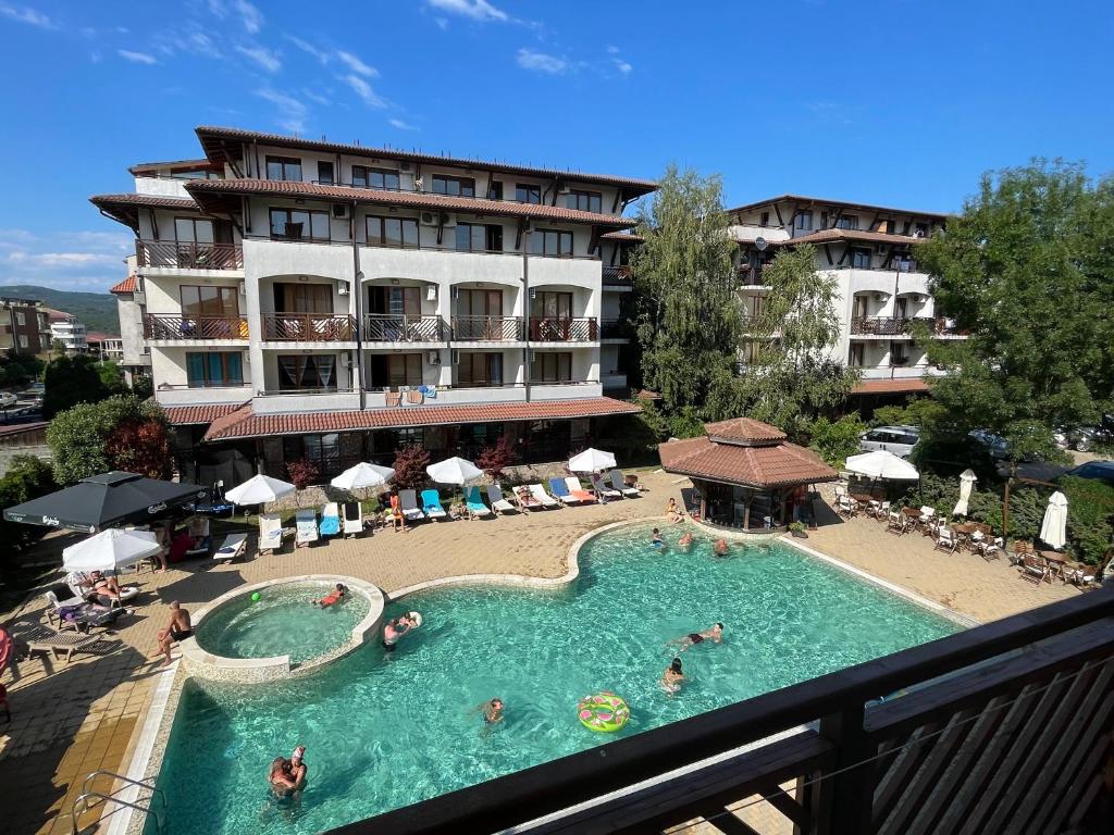 a hotel with a swimming pool with people in it at Apartments Resort BG in Primorsko