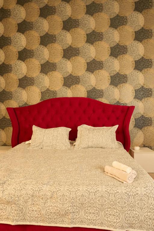 a red bed with a red headboard with two pillows at Max Royal in Almaty