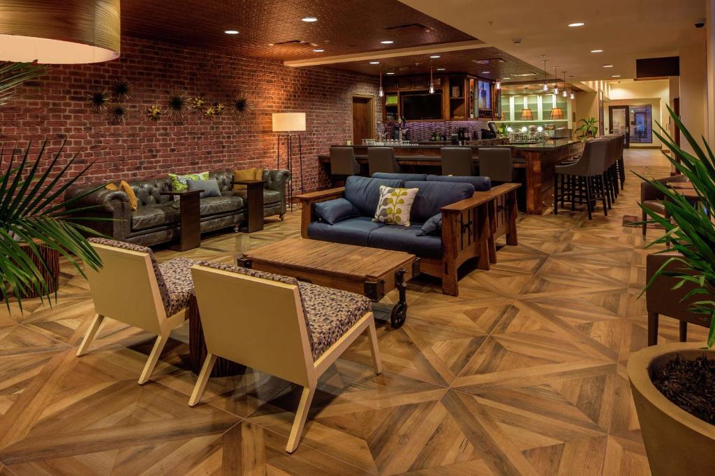 a lobby with couches and tables and a bar at Hilton Garden Inn Uniontown in Uniontown