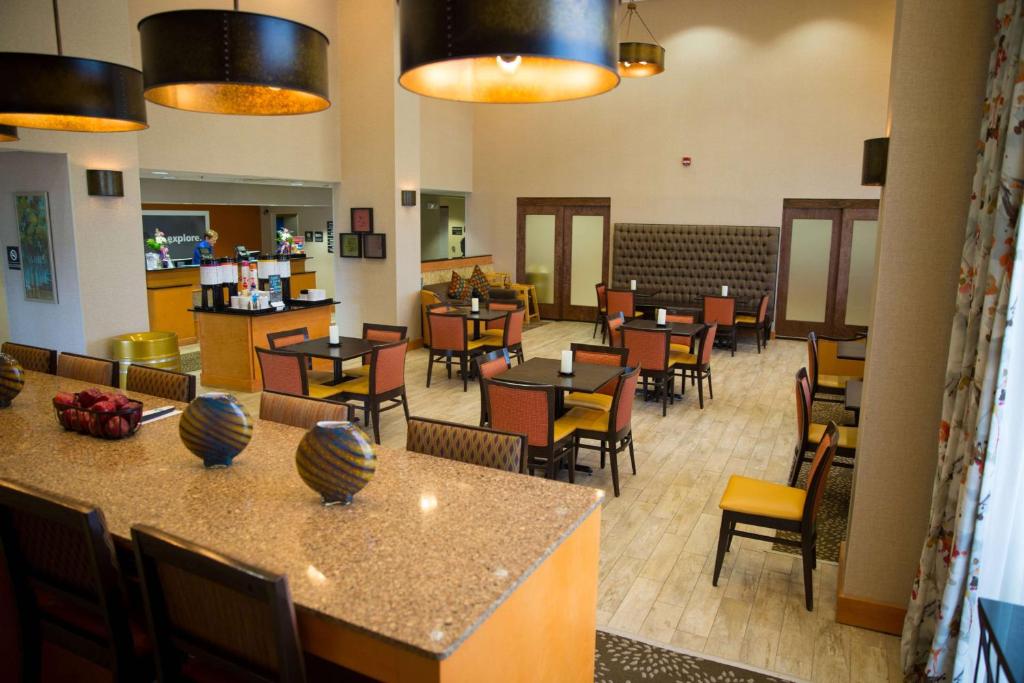 a restaurant with tables and chairs and a cafeteria at Hampton Inn & Suites Grenada in Grenada