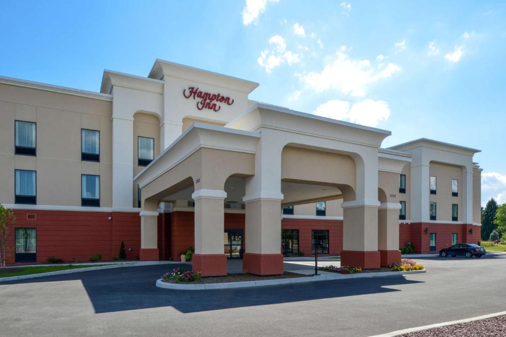 a hotel building with a sign on the front of it at Hampton Inn Potsdam in Potsdam