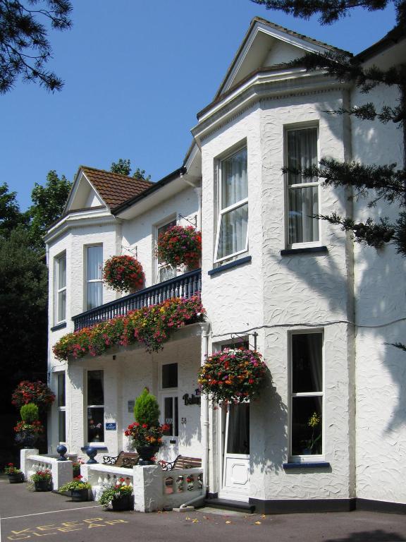 a white house with flowers in the window boxes at Balincourt in Bournemouth