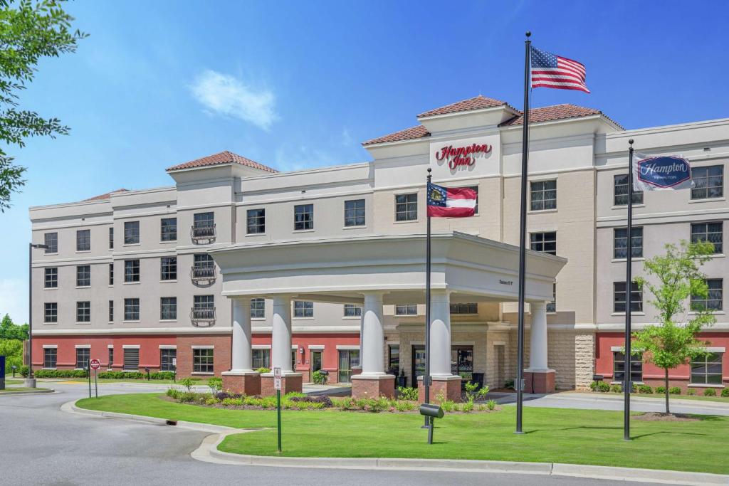 un edificio de oficinas con dos banderas delante en Hampton Inn Columbus/South-Fort Benning, en Columbus