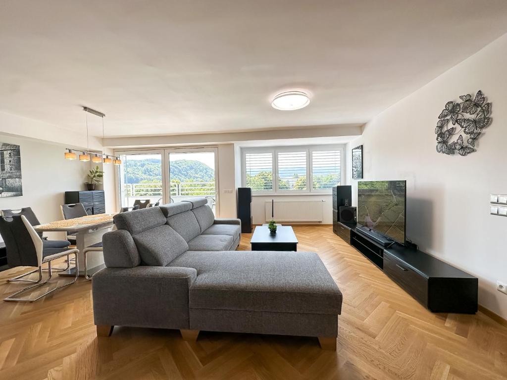 a living room with a couch and a tv and a table at LUX residence, A/C, VIP parking, city view in Banská Bystrica