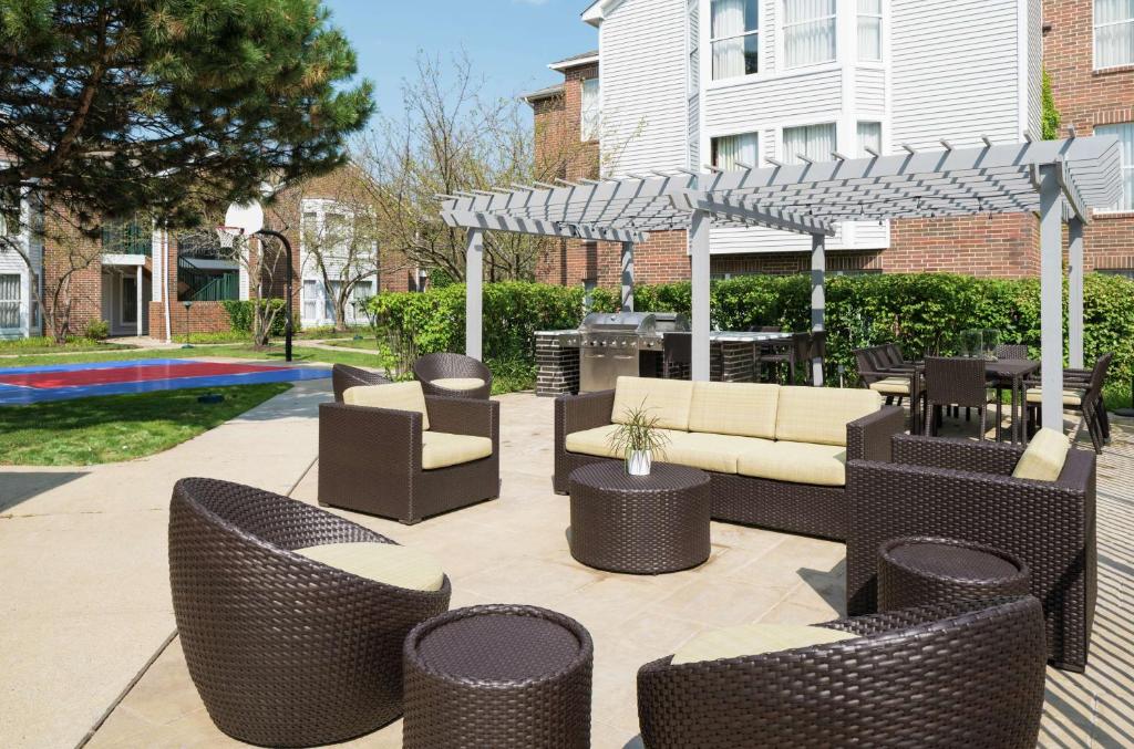 un patio con muebles de mimbre y pérgola en Homewood Suites by Hilton Chicago - Schaumburg en Schaumburg