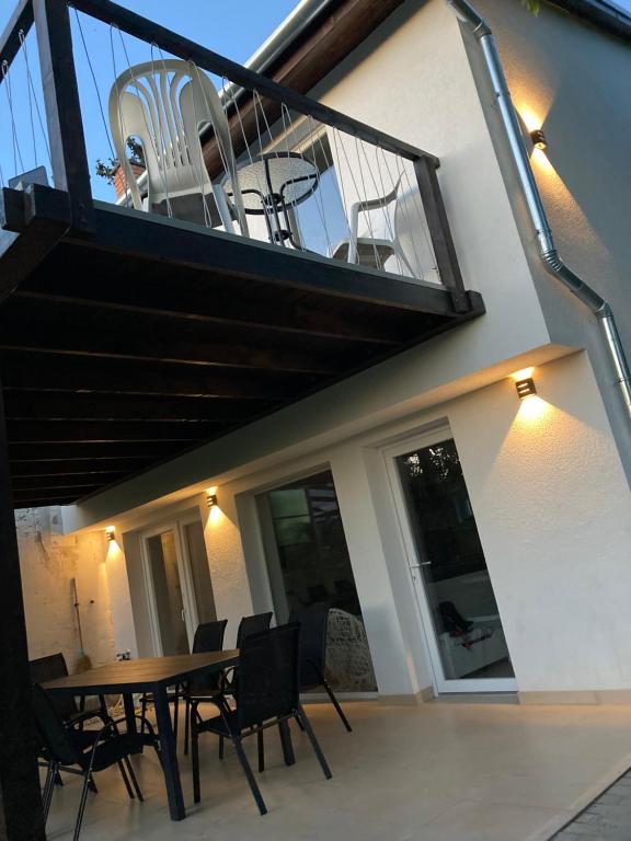 einen Balkon mit einem Tisch und Stühlen auf einem Haus in der Unterkunft Sun&Fun Vendégház in Balatonakarattya