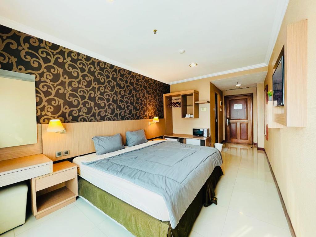 um quarto com uma cama grande num quarto em Pretty Room Studio Apartment at Galeri Ciumbuleuit 1st Tower em Bandung