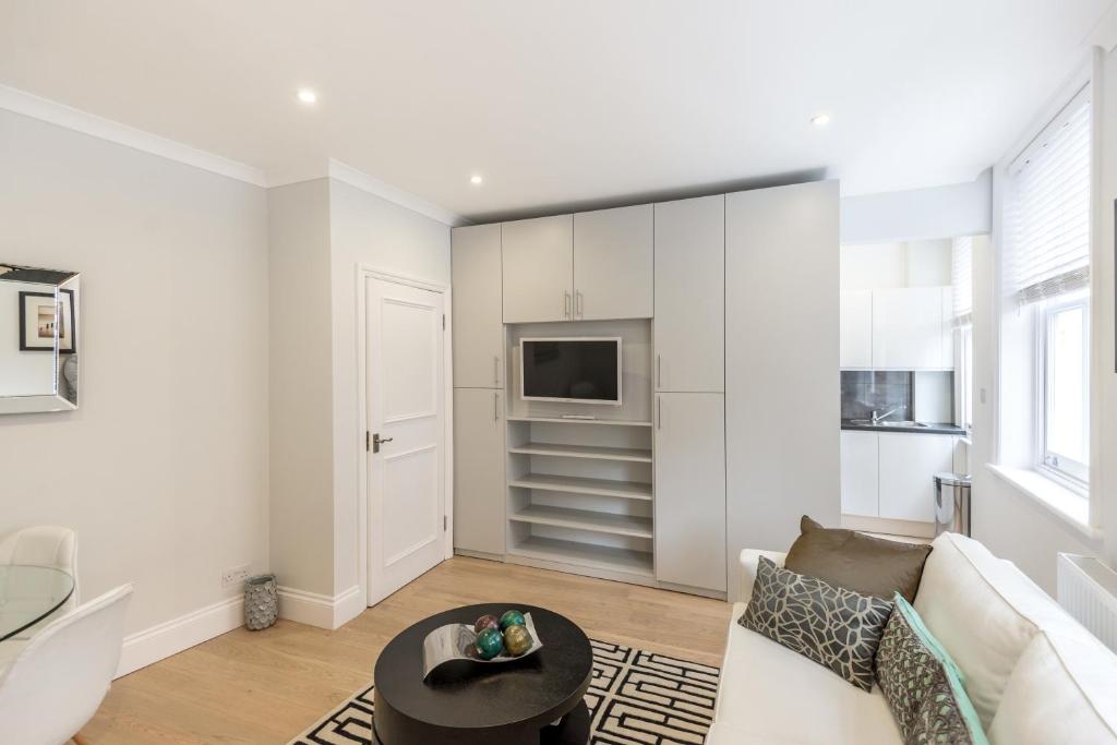 a living room with a couch and a table at High Street Kensington Apartment in London