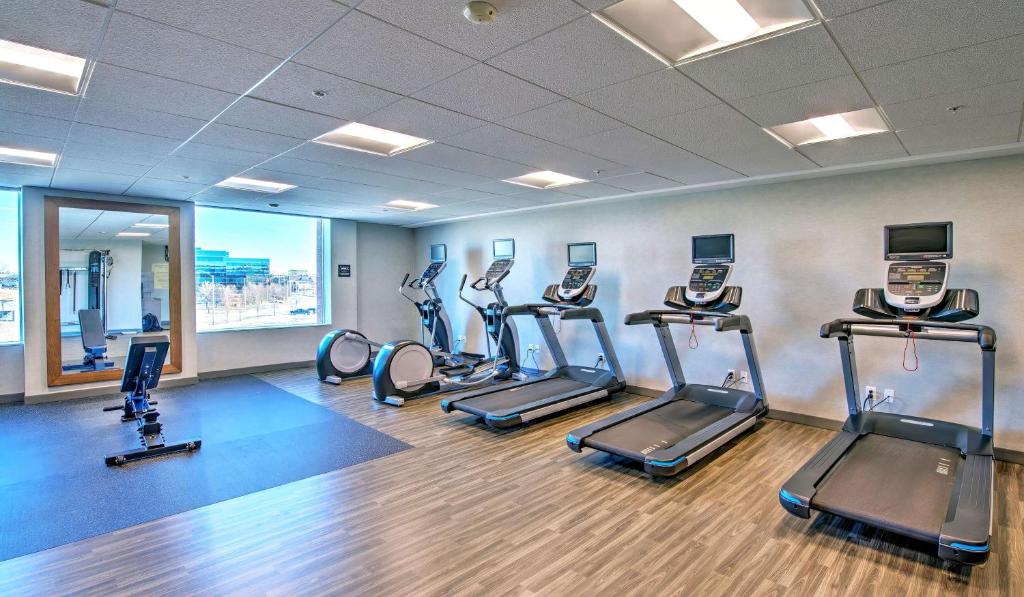 a gym with treadmills and ellipticals in a room at Hampton by Hilton Ottawa in Ottawa