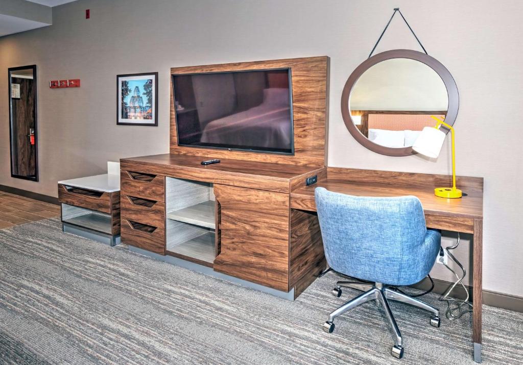 a desk with a television and a blue chair at Hampton by Hilton Ottawa in Ottawa
