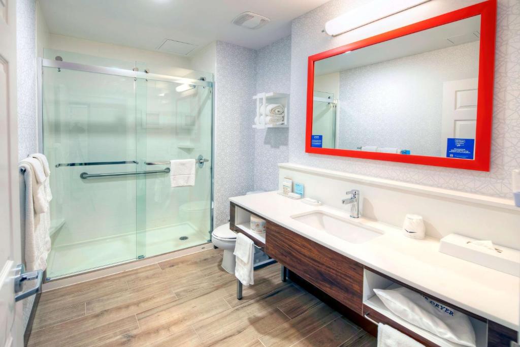 a bathroom with a shower and a sink and a mirror at Hampton by Hilton Ottawa in Ottawa