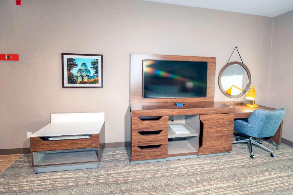a desk with a television and a chair in a room at Hampton by Hilton Ottawa in Ottawa