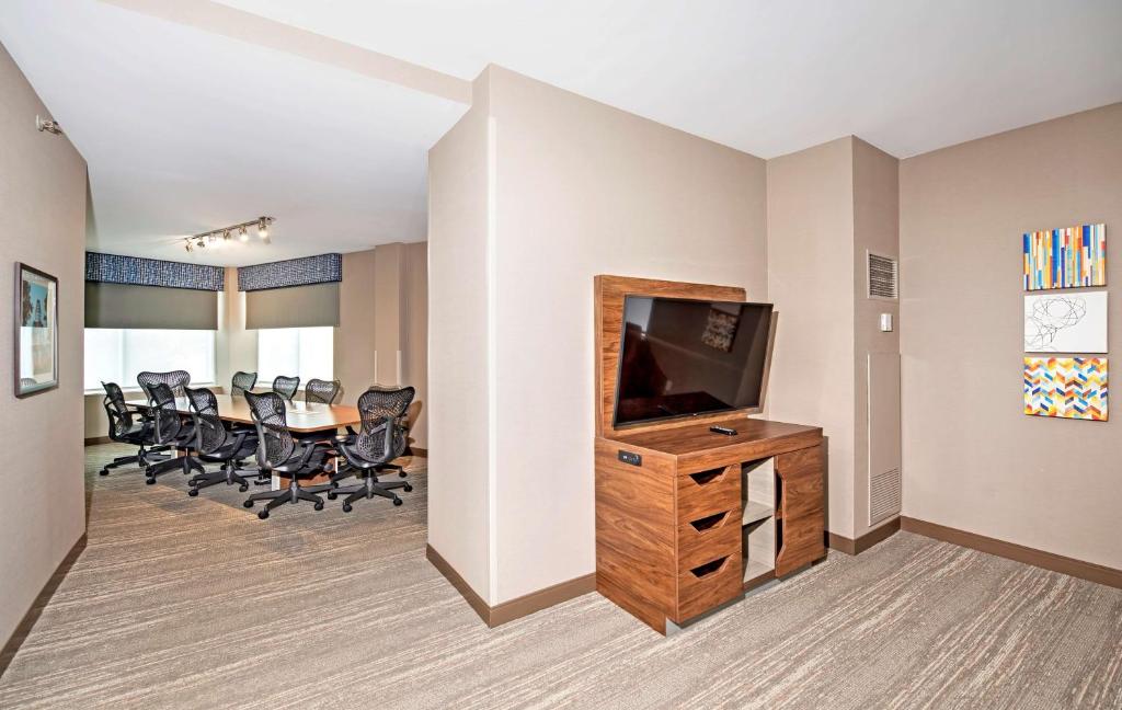 a conference room with a television and a table with chairs at Hampton by Hilton Ottawa in Ottawa