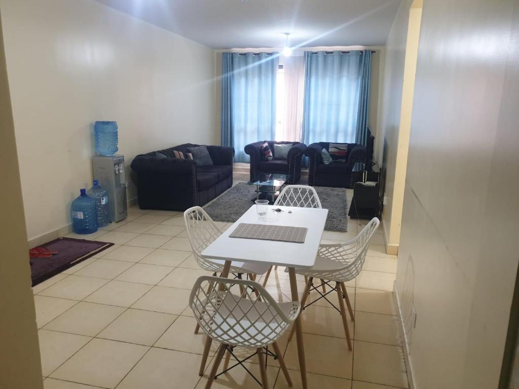 a living room with a white table and chairs at Spacious 3bedroom in Greatwall Gardens in Athi River