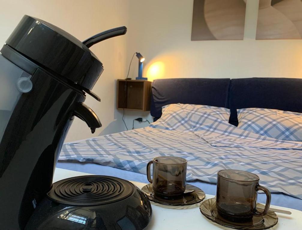 uma cafeteira e duas chávenas numa mesa ao lado de uma cama em Well em Filettole