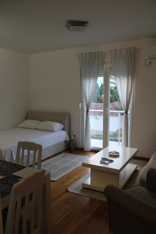 Cet appartement comprend une chambre avec un lit et un salon avec une table. dans l'établissement Delta studio apartman, à Podgorica