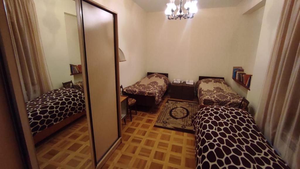a bedroom with two beds and a large mirror at Гаварский уют in Gavarr