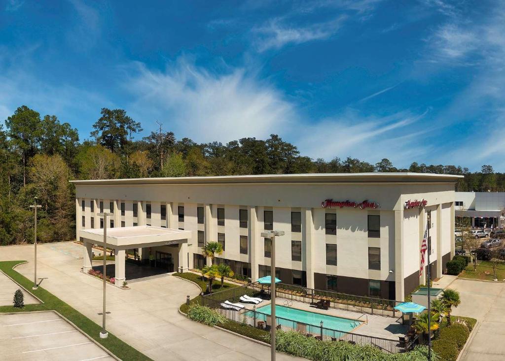  Elle offre une vue aérienne sur un hôtel doté d'une piscine. dans l'établissement Hampton Inn Covington/Mandeville, à Covington