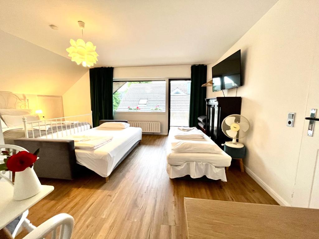a hotel room with two beds and a window at VILLA ORCHARD Frankfurt in Zeilsheim
