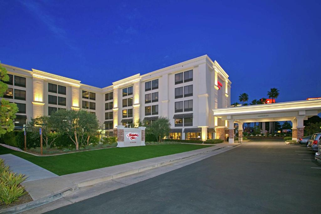a large white building with a parking lot in front of it at Hampton Inn by Hilton San Diego - Kearny Mesa in San Diego