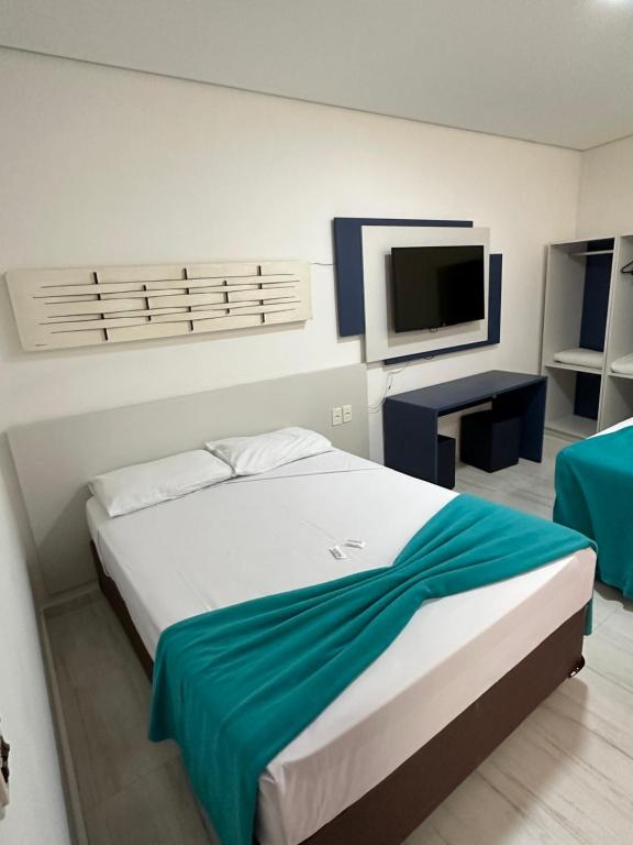 um quarto com uma cama grande e uma televisão em Zurique Sorocaba Hotel em Sorocaba